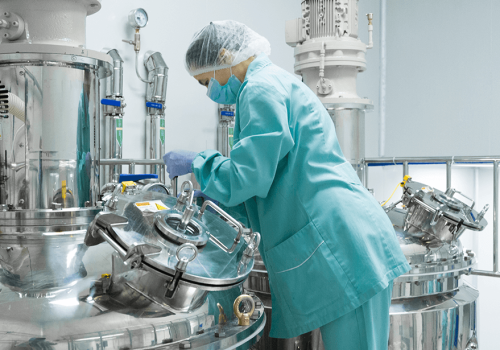trabalhador-de-mulher-fabrica-farmaceutica-em-roupas-de-protecao-operando-a-linha-de-producao-em-ambiente-esteril (1)